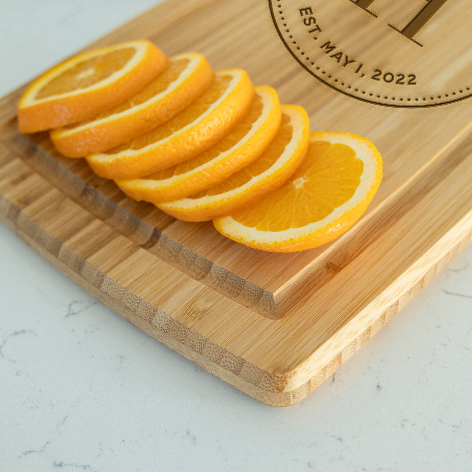 https://www.qualtry.com/cdn/shop/products/staged_QUAL1172LargeHandledCuttingboardwithJuiceGrooves_stagedbeautyshotonwhitequartzwithoranges_H_squarecrop_1800x1800.jpg?v=1689087725